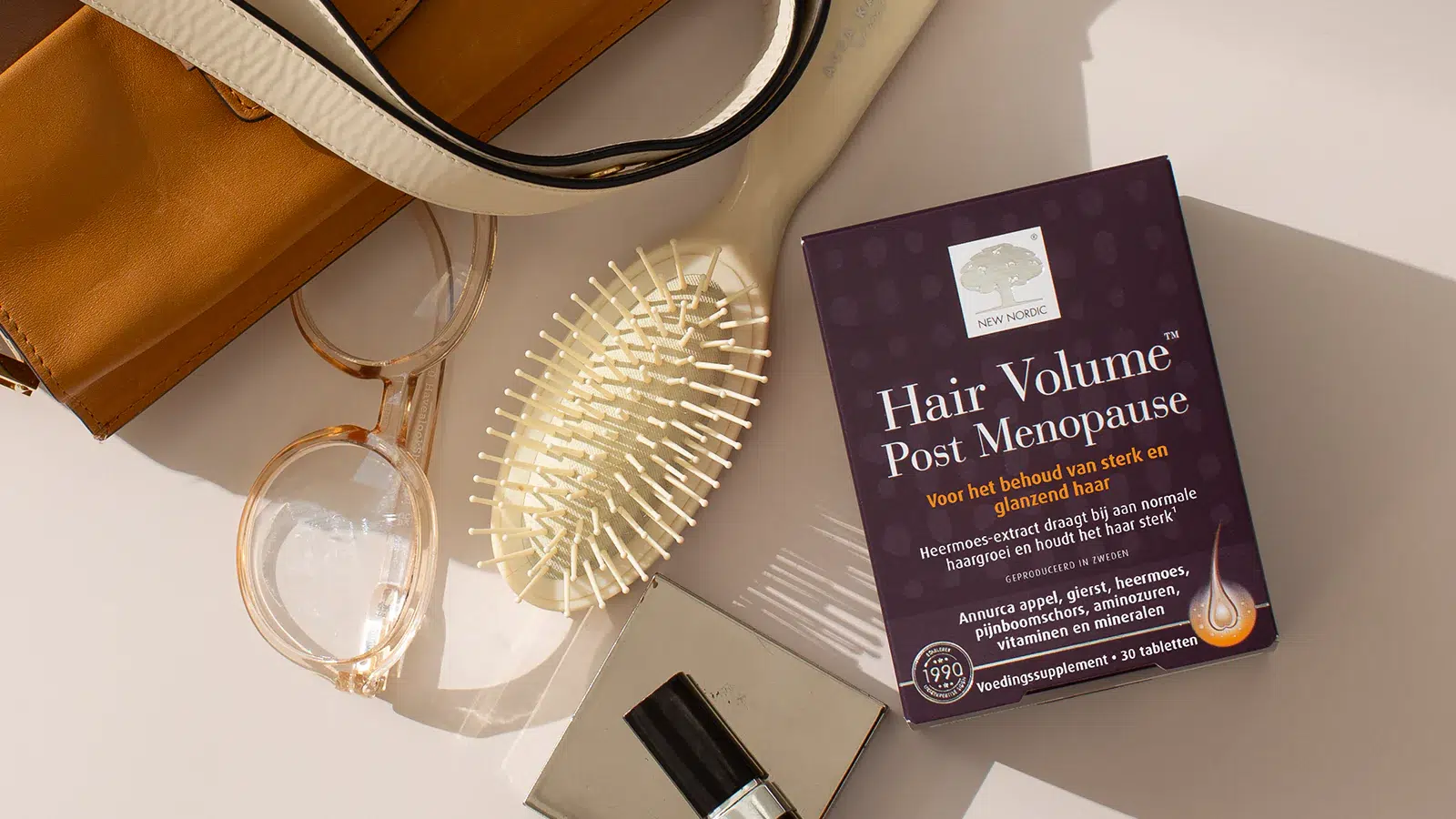 Herbal Schools 46 New Nordic Hair Volume™ Post Menopause weergegeven met persoonlijke items op een lichte ondergrond.