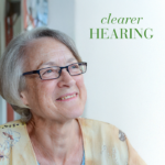 Elderly woman smiling displayed with text Clearer Hearing.