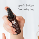 Hand holding the Hair Volume™ Shine Serum bottle with text Apply before blow-drying.