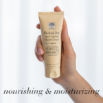 Hand holding the light beige Herbal Joy™ Anti-Ageing Hand Cream, with text Nourishing and moisturizing.