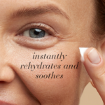 Close-up of a woman with beautiful skin applying eye cream with text Instantly rehydrates and soothes.