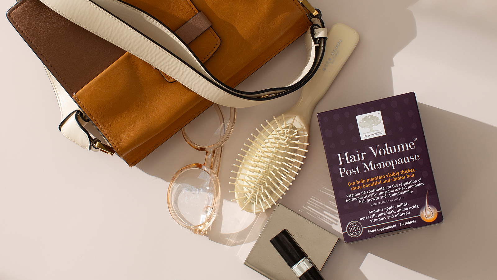 Enhanced Hair Quality with Hair Volume™ Post Menopause 15 New Nordic Hair Volume™ Post Menopause displayed with personal items on a light surface.