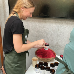 Herbal Schools 33 Woman experimenting with herbs at a herbal school event, learning about and engaging with plants.