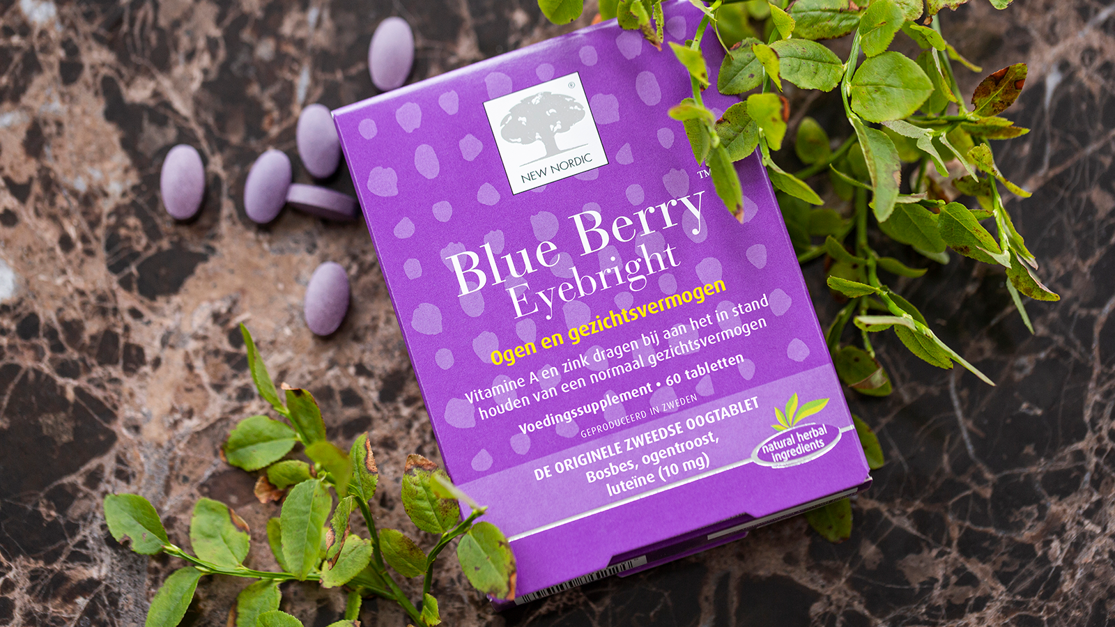 Blue Berry Eyebright™ verpakking met paarse tabletten en groene bladeren op donkere achtergrond.